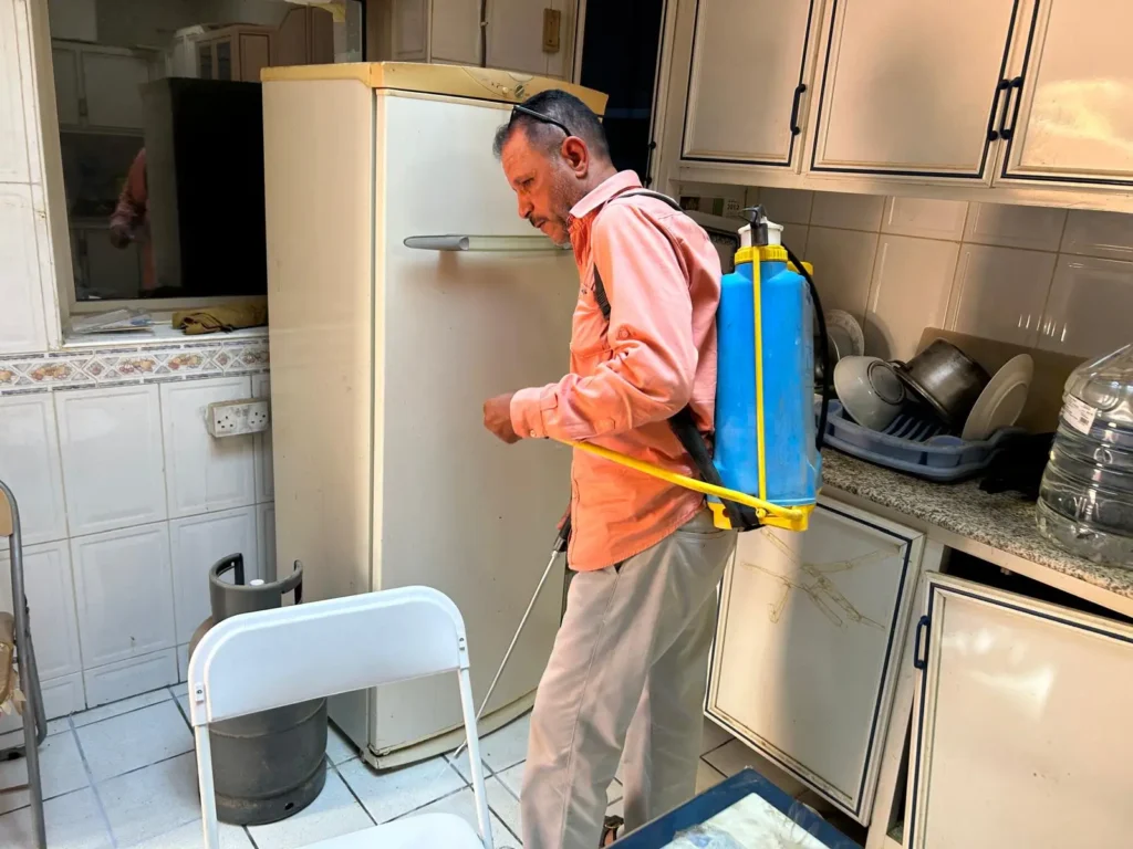 صورة لفني مكافحة حشرات أثناء رش مبيدات